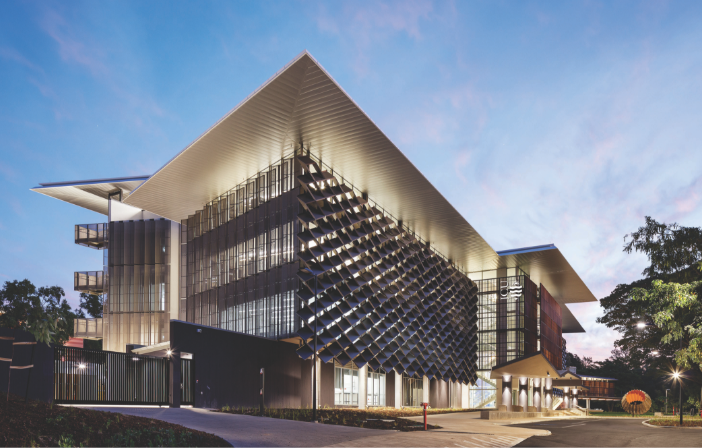 A modern university building with dramatic architecture at dusk.