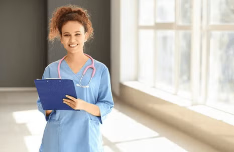Nursing student smiling while holding patient record.